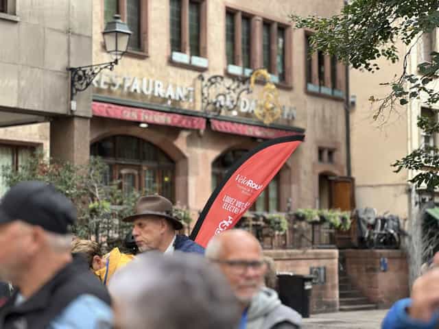 VéloRouge flag and walking-tour guests outside an Alsatian restaurant